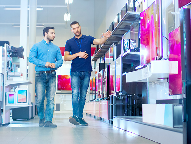 Retail salesman showing customer televisions