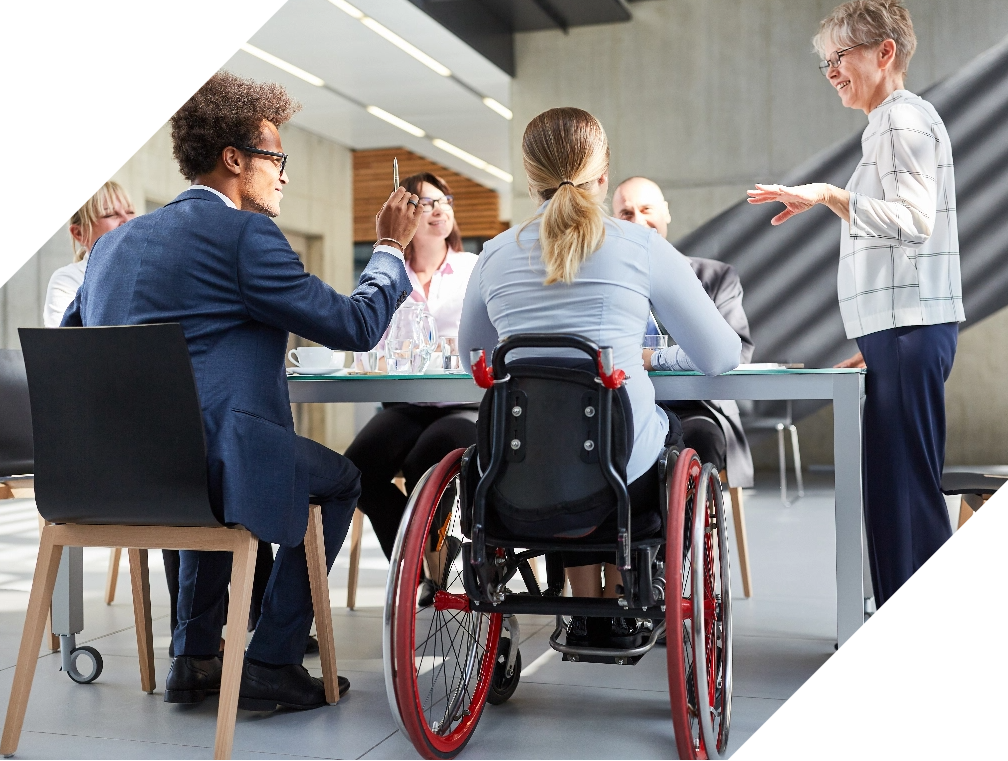Woman in a wheelchair having a discussion with a diverse coworkers
