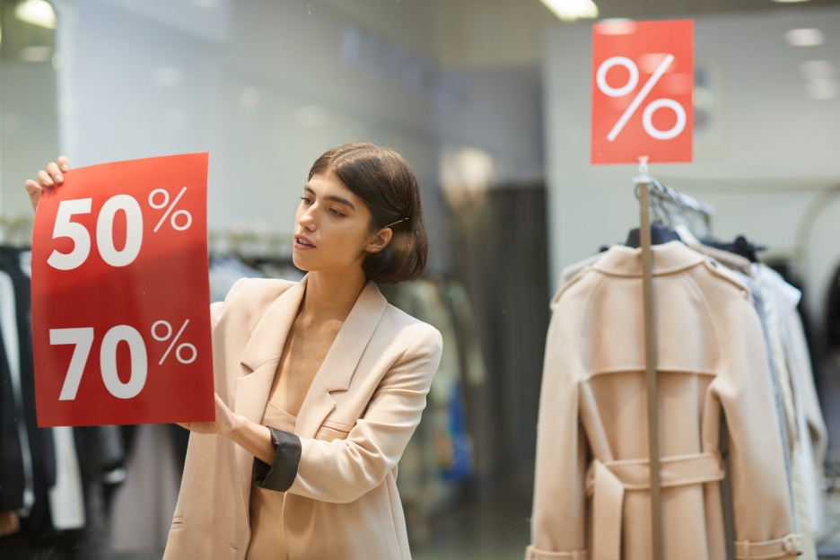 retail manager posting marketing materials on window