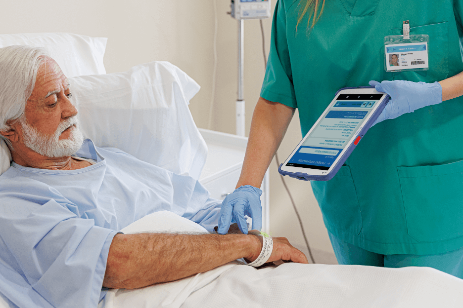 Nurse checking wrist lable on a elderly male patient with a scanner