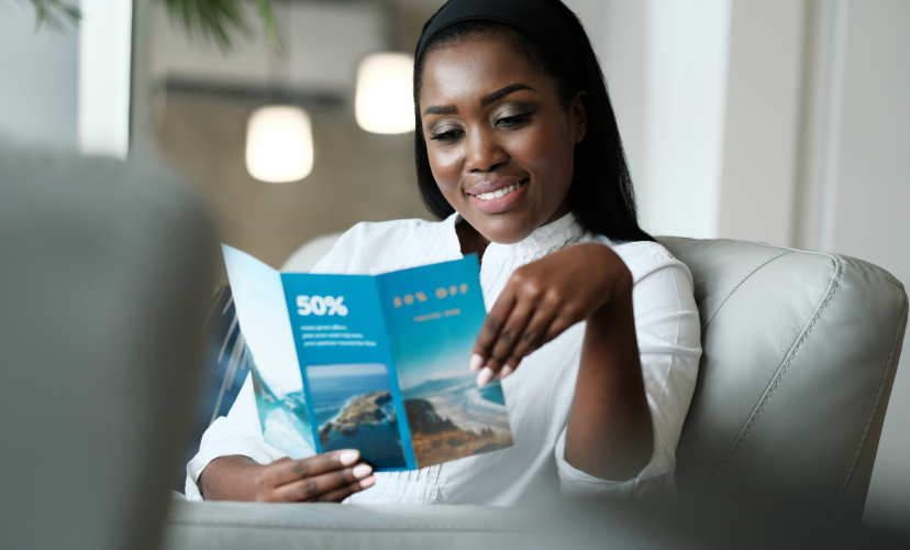Smiling woman reading a printed direct mail marketing.