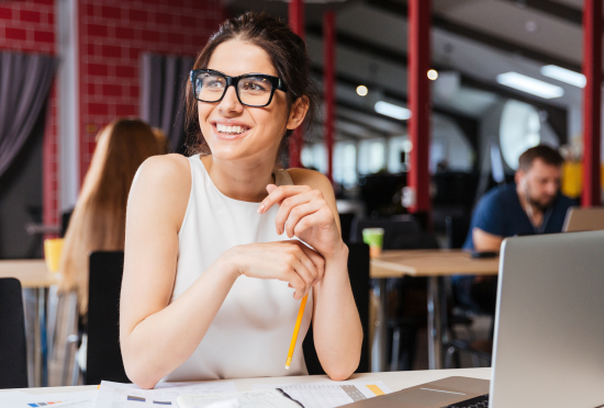 A smiling creative female designer looking away from her branding tasks.